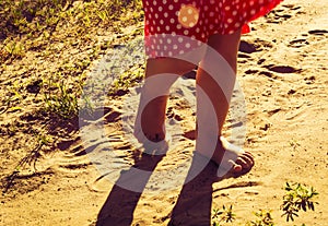 Children's pinches walk on warm sand. instagram style photo
