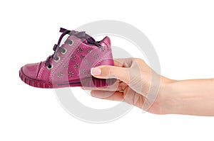 Children`s pink shoe in hand