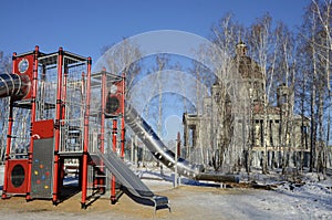 Children`s play construction against the backdrop of an Orthodox Cathedral under construction in Chelyabinsk, Russia.