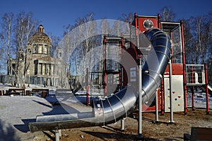 Children`s play construction against the backdrop of an Orthodox Cathedral under construction in Chelyabinsk, Russia.