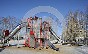 Children`s play construction against the backdrop of an Orthodox Cathedral under construction in Chelyabinsk, Russia.