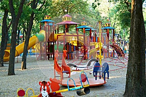 Children`s playground in a city Park early in the morning, various swings and carousels