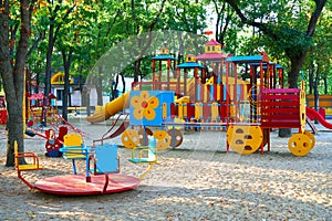 Children`s playground in a city Park early in the morning, various swings and carousels