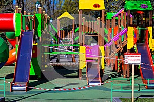 Children`s playground closed and wrapped in alarm caution tape for global coronavirus quarantine