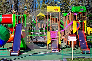 Children`s playground closed and wrapped in alarm caution tape for global coronavirus quarantine