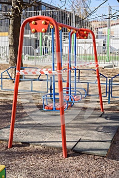 Children`s playground closed and wrapped in alarm caution tape for global coronavirus quarantine.No children on