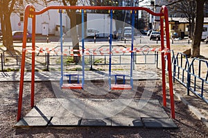 Children`s playground closed and wrapped in alarm caution tape for global coronavirus quarantine.No children on