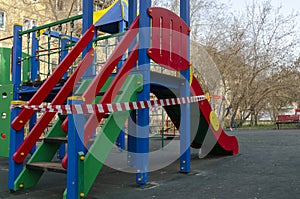 Children`s playground closed and wrapped in alarm caution tape for global coronavirus quarantine.No children on playgrounds