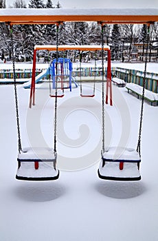 Children`s playground covered with snow