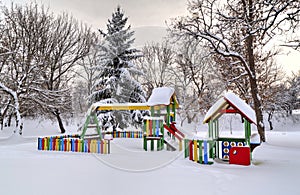 Children`s playground covered with snow