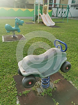 Children`s playground with cyan colored car spring toy rider