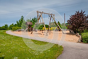 Children`s playground equipped with wooden swings and slides.