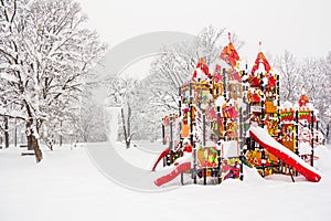 children\'s playground in the form of a fairytale castle during a snowfall in a winter park.