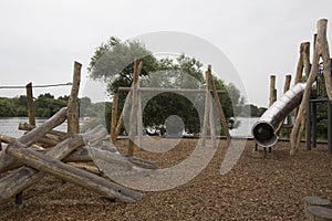 Children`s playground made of environment, eco-friendly materials. Wooden tree trunk sides, swings, net bridges, climbers.