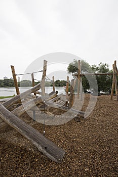 Children`s playground made of environment, eco-friendly materials. Wooden tree trunk sides, swings, net bridges, climbers.