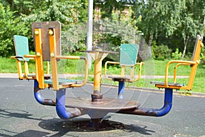 Children`s playground outdoor in summer. yellow metal carousel