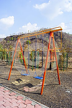 Children\'s playground swing set at mountain village Kalakund near Mhow, Indore, Madhya Pradesh on a sunny summer day. Indian