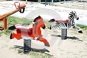 Children`s playground with swings in the form of a zebra and a h