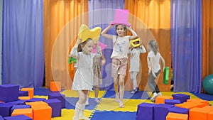 Children`s playroom. Little girls defile with soft toys.