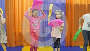 Children`s playroom. Little girls defile with soft toys.