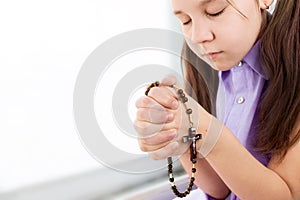 children's prayer. Christian prayer. Wooden rosary beads with a cross