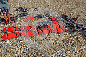 Children`s red life jackets lined up on the beach