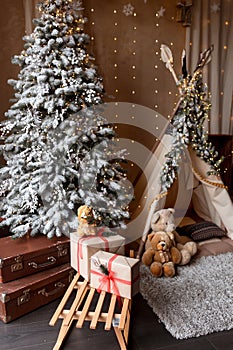 Children& x27;s room decorated in Christmas style. Wooden sleigh, gifts and hut for children to play.