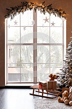 Children's room decorated in Christmas style. Wooden sleigh, gifts and hut for children to play.