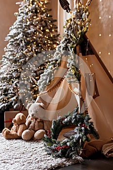 Children& x27;s room decorated in Christmas style. Wooden sleigh, gifts and hut for children to play.