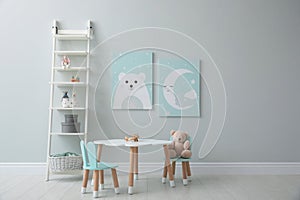 Children`s room interior with table and cute pictures on wall