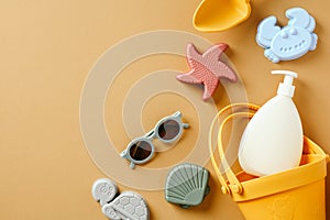 Children\'s sand molds, sun lotion, sunglasses on sand color background