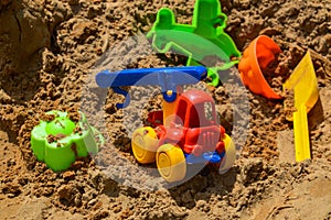 Children`s sandbox on the playground for games with toys for children by truck, car, excavator, sand dressers with a spatula