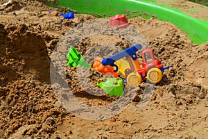 Children`s sandbox on the playground for games with toys for children by truck, car, excavator, sand dressers with a spatula