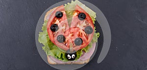 Children`s sandwich in the form of a ladybug on a dark background. Children`s table setting. Children`s menu