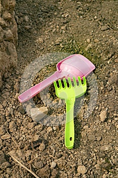 Children`s shovel and rake lie on the ground