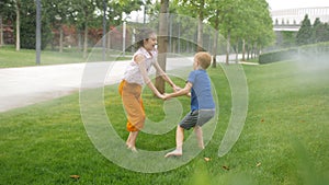 Children's sincere joy from the water drops of lawn sprinklers in the park.