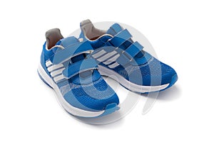 Children's sports sneakers in blue with white stripes. Sport shoes.