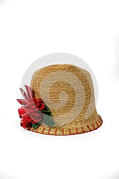 Children\'s straw hat decorated with artificial flowers on a white