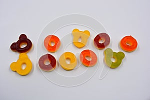 Children\'s sweets in the form of multi-colored donuts, chewable, gelatin sweets are located on a white background.