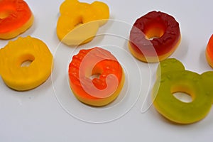 Children\'s sweets in the form of multi-colored donuts, chewable, gelatin sweets are located on a white background.