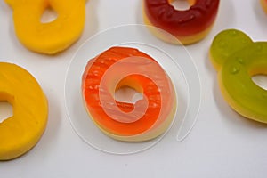 Children\'s sweets in the form of multi-colored donuts, chewable, gelatin sweets are located on a white background.