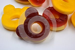 Children\'s sweets in the form of multi-colored donuts, chewable, gelatin sweets are located on a white background.