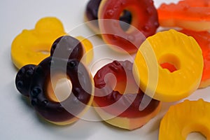 Children\'s sweets in the form of multi-colored donuts, chewable, gelatin sweets are located on a white background.