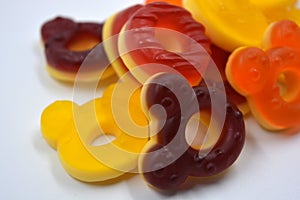 Children\'s sweets in the form of multi-colored donuts, chewable, gelatin sweets are located on a white background.