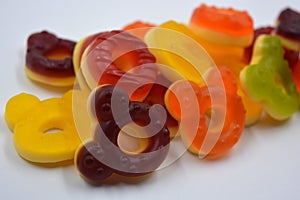 Children\'s sweets in the form of multi-colored donuts, chewable, gelatin sweets are located on a white background.