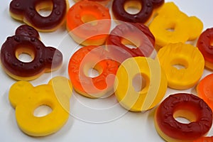 Children\'s sweets in the form of multi-colored donuts, chewable, gelatin sweets are located on a white background.