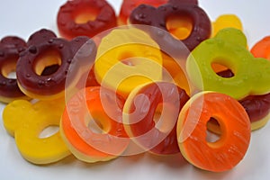 Children\'s sweets in the form of multi-colored donuts, chewable, gelatin sweets are located on a white background.