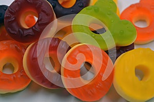 Children\'s sweets in the form of multi-colored donuts, chewable, gelatin sweets are located on a white background.