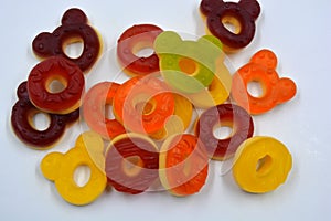 Children\'s sweets in the form of multi-colored donuts, chewable, gelatin sweets are located on a white background.