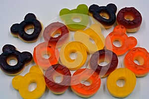 Children\'s sweets in the form of multi-colored donuts, chewable, gelatin sweets are located on a white background.